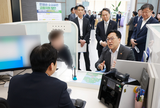 김병환 금융위원장이 8일 서울 중구 신한은행 본점에서 관계자로부터 소상공인 지원 프로그램에 대한 설명을 듣고 있다. 뒷줄 오른쪽부터 이재연 서민금융진흥원장, 진옥동 신한금융 회장, 이태훈 은행연합회 전무. [금융위원회 제공]